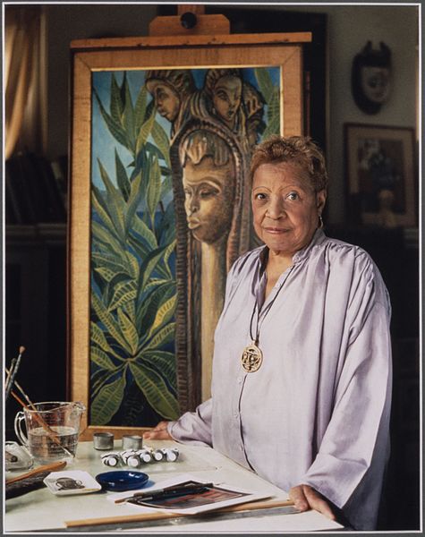 Lois Mailou Jones standing in front of one of her paintings